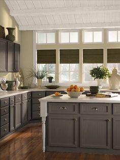 a kitchen filled with lots of counter top space next to a window covered in blinds