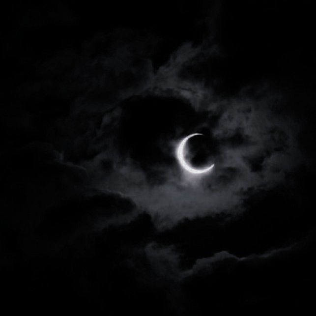 the moon is seen through clouds during a solar eclipse in this black and white photo