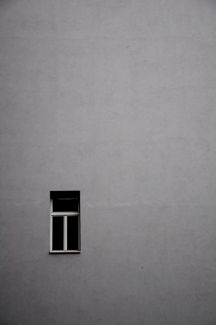 an open window on the side of a gray building with white trim and black shutters