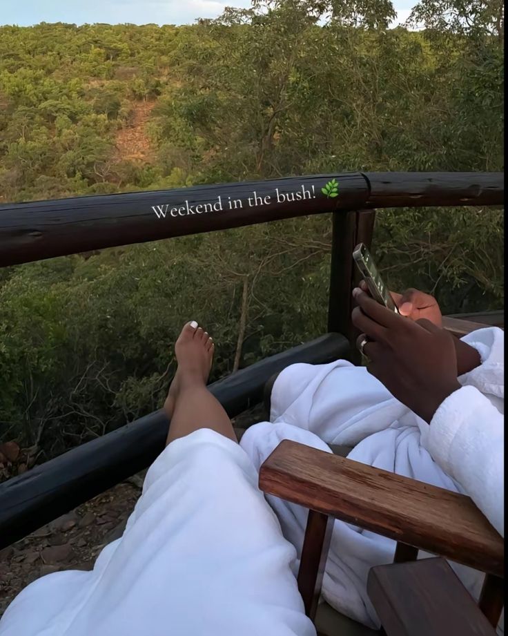 a person laying down on a deck with their feet in the air reading a book