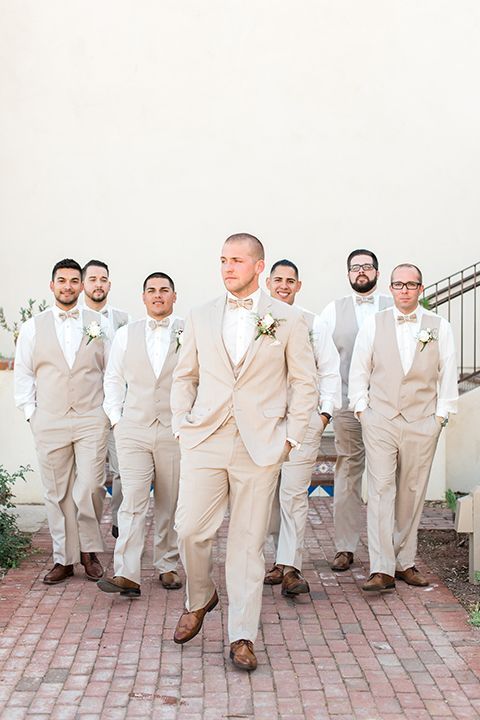 a group of men standing next to each other on top of a brick floored walkway