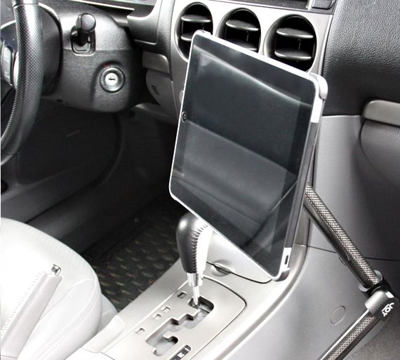 the interior of a car with an electronic device attached to the dash board and steering wheel