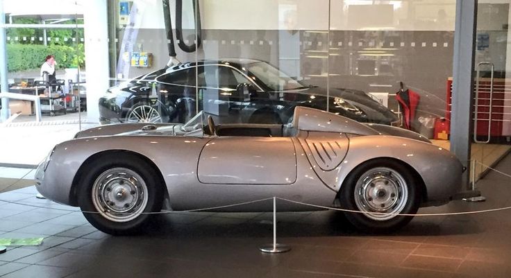 an old car is on display in a glass case with the hood up and side doors open