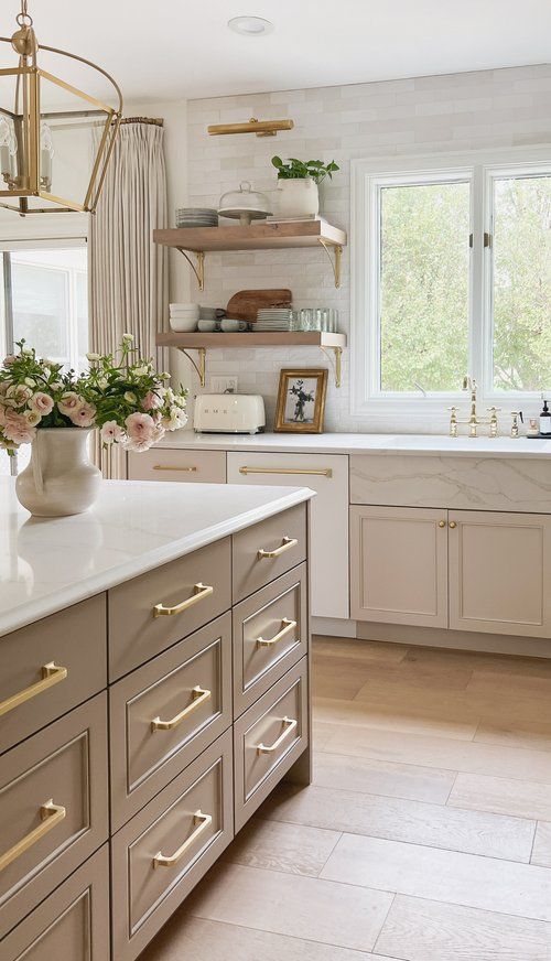 a large kitchen with white cabinets and gold handles on the countertops, along with open shelving