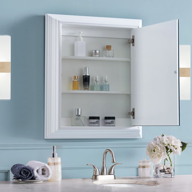 the medicine cabinet in the bathroom is open to reveal its own personal care products and flowers