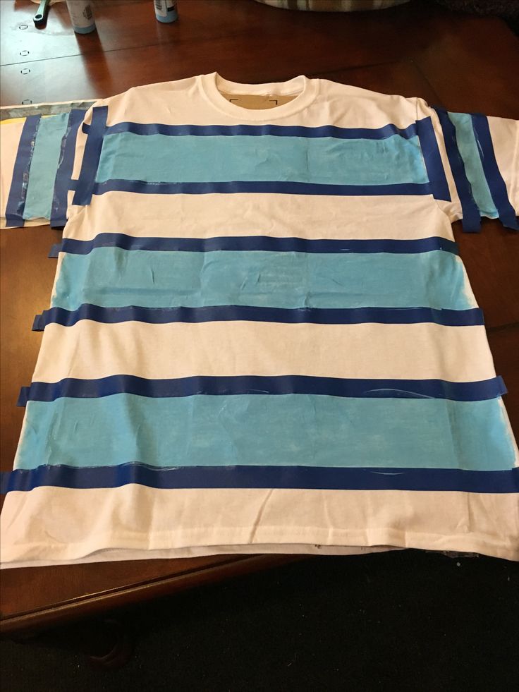 a blue and white striped shirt sitting on top of a wooden table