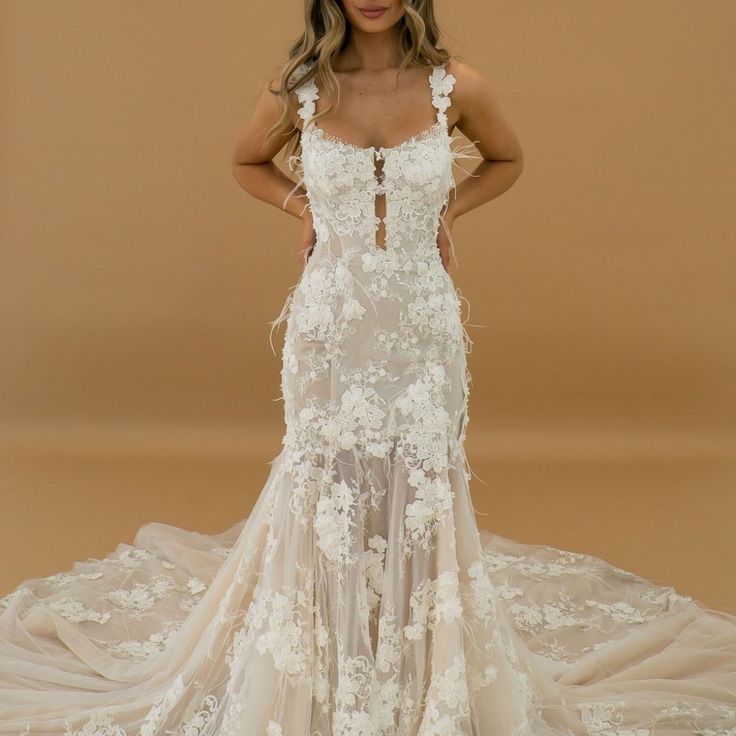 a woman in a wedding dress posing for the camera with her hands on her hips