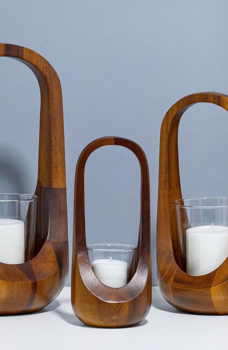 two wooden vases with candles in them sitting next to each other