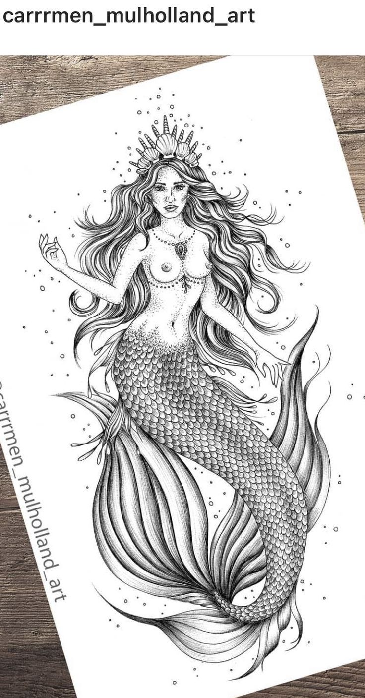 a drawing of a mermaid sitting on top of a wooden table