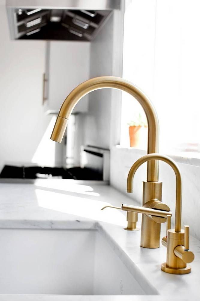 a gold faucet in a white kitchen