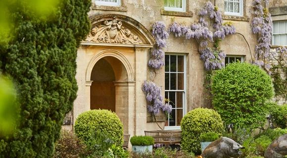 a large house with purple flowers on the front