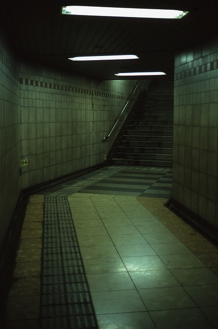 an empty subway station with stairs and tiled floors