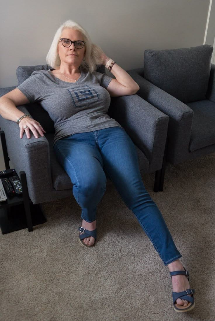 a woman sitting on a couch with her legs crossed