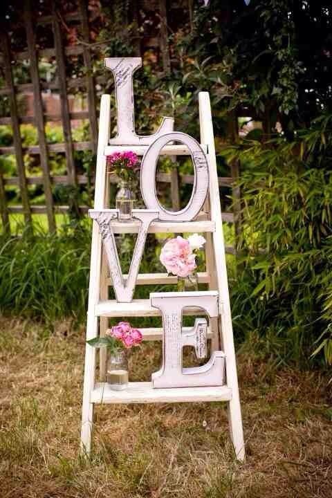 an old ladder is decorated with flowers and the word love