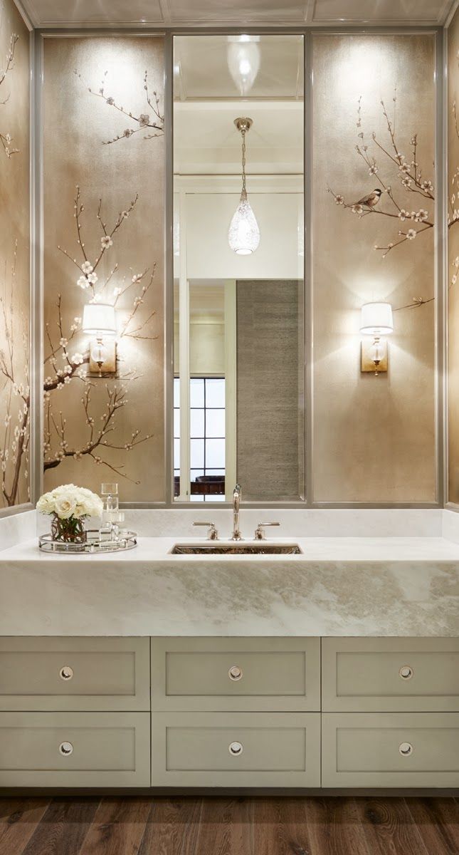 a bathroom sink sitting under a mirror next to a bath tub with flowers on it