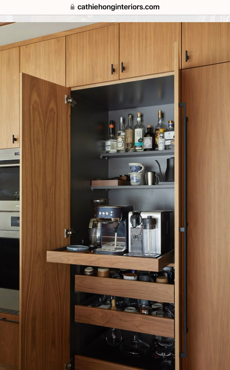 an open cabinet in the middle of a kitchen