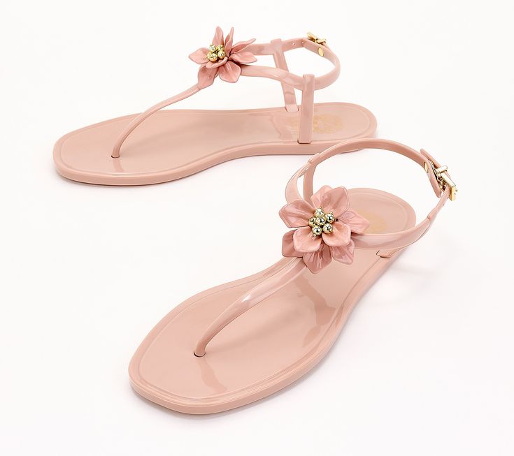 Remember the jelly sandals you used to wear as a kid? They're back with a chic gloss and a floral embellishment that the grown-up version of you will love. Pair with a printed sarong and wear them poolside or with a cropped linen pant for brunch. The options are endless when it comes to this cool summer accessory. From Vince Camuto. Pink Sandals For Spring Poolside, Pink Summer Sandals For Poolside, Pink Sandals For Poolside Spring, Pink Sandals For Beach And Poolside, Chic Pink Jelly Sandals For Vacation, Summer Pink Sandals For Poolside, Pink Sandals For Poolside And Beach Season, Pink Sandals For Poolside Summer, Plastic Jelly Sandals For Summer Vacation