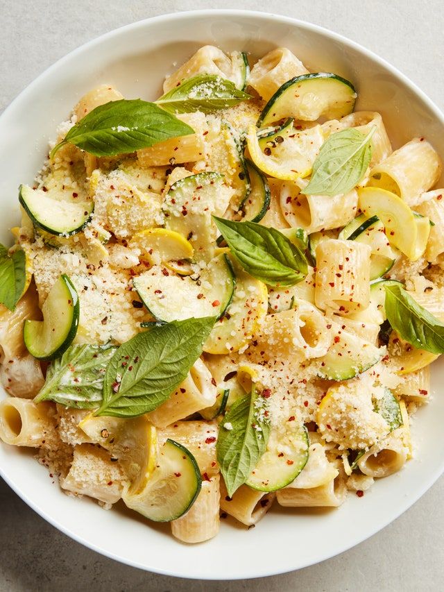 a white bowl filled with pasta and vegetables