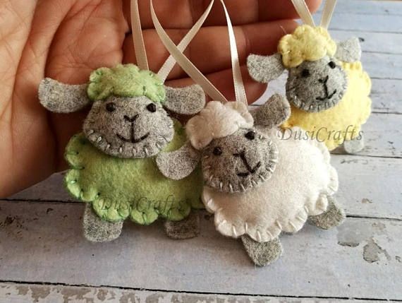 three small stuffed sheep hanging from a string