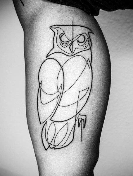 a black and white photo of an owl tattoo on the right thigh, with lines drawn across it