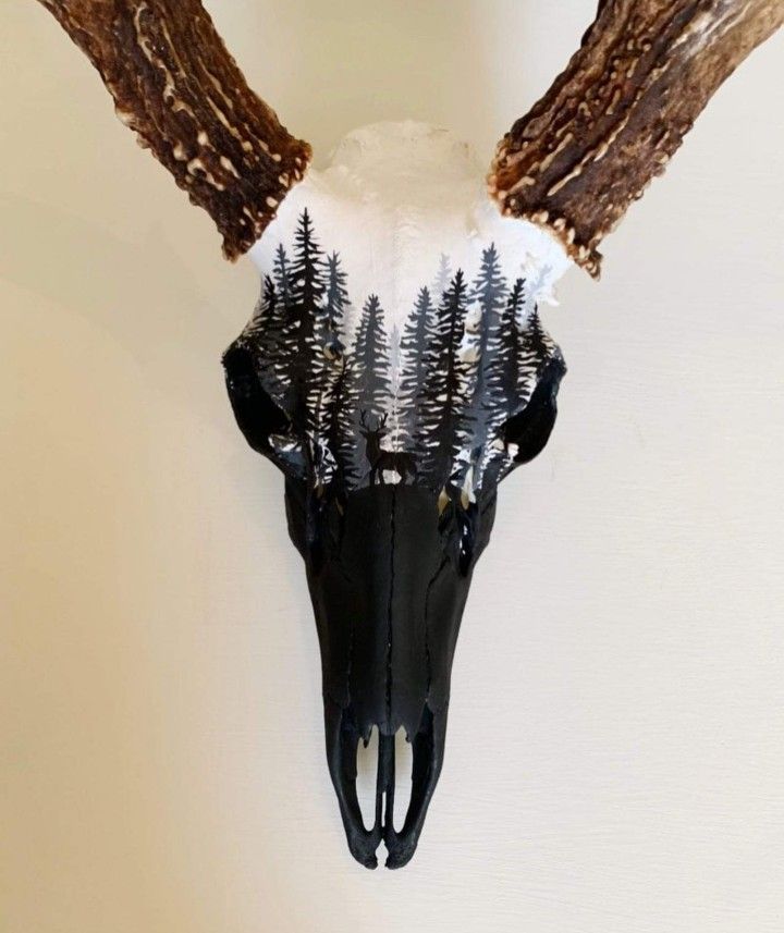 a deer's head with trees on it and antlers hanging from the wall