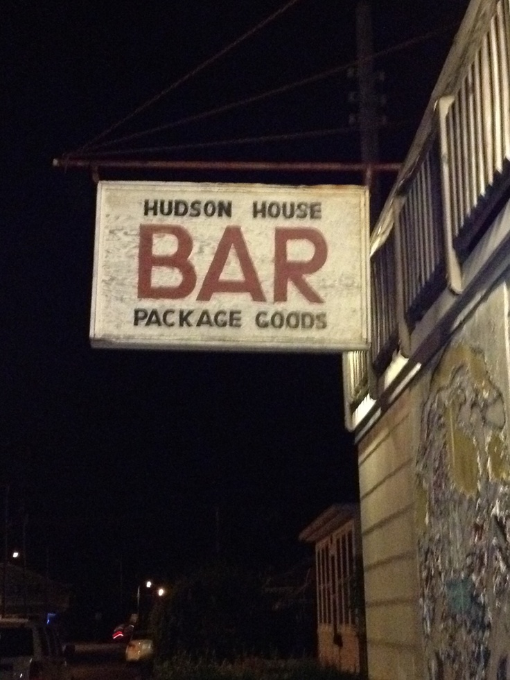 a sign hanging from the side of a building that says hudson house bar package goods