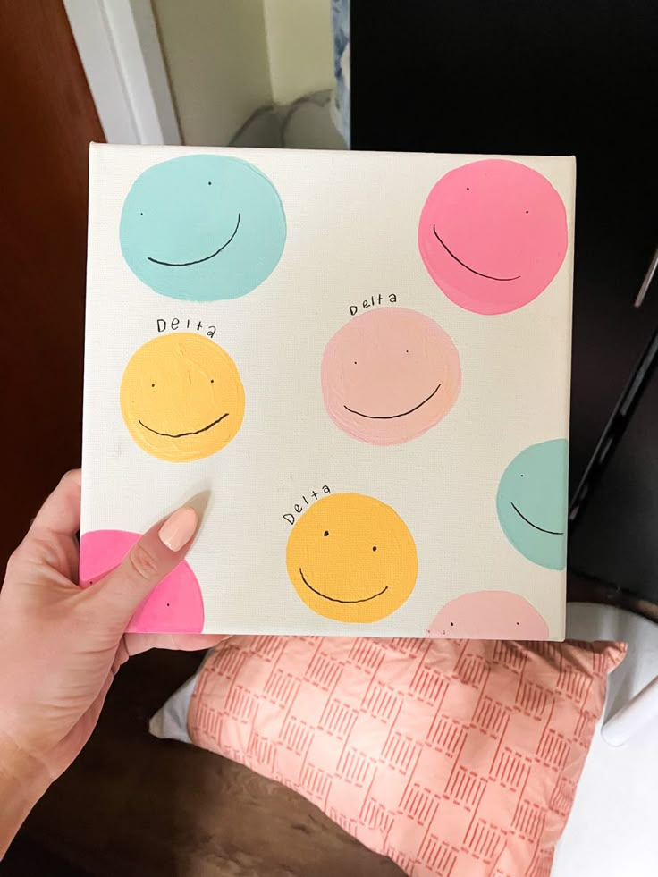 a person holding up a card with smiley faces on it