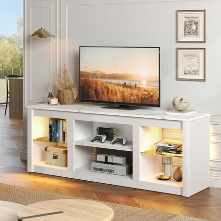 a flat screen tv sitting on top of a white entertainment center in a living room