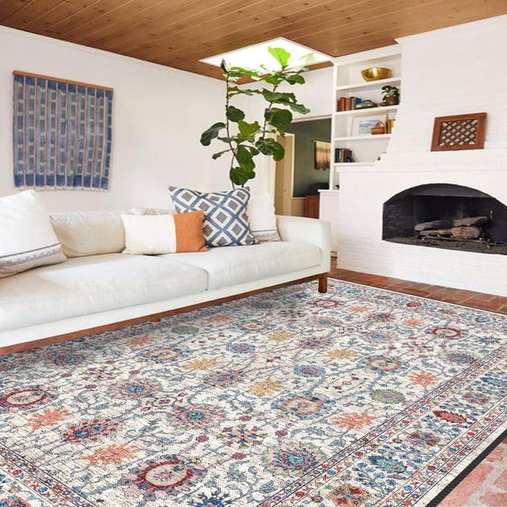 a living room with a couch, rug and fireplace