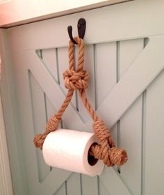 a roll of toilet paper hanging from a rope attached to a door with two black handles