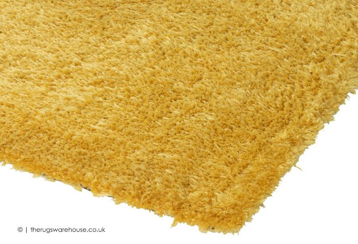 a close up view of a yellow shaggy rug on a white background with the top corner slightly down