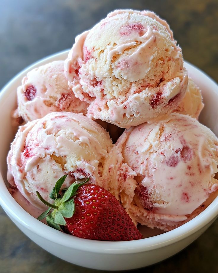 a bowl filled with ice cream and strawberries