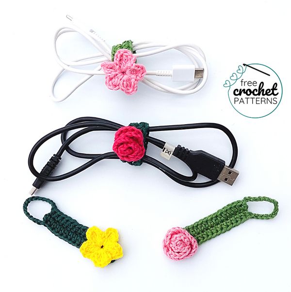 two crocheted flowers are connected to a charger and power cord with the cords attached