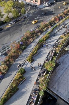 an aerial view of a city street with people walking on the sidewalk and cars driving down it