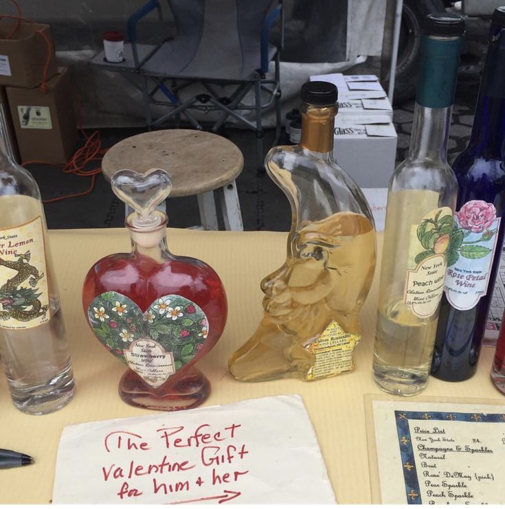 an assortment of wine bottles on a table with a note that says, the perfect valentine gift for him and her