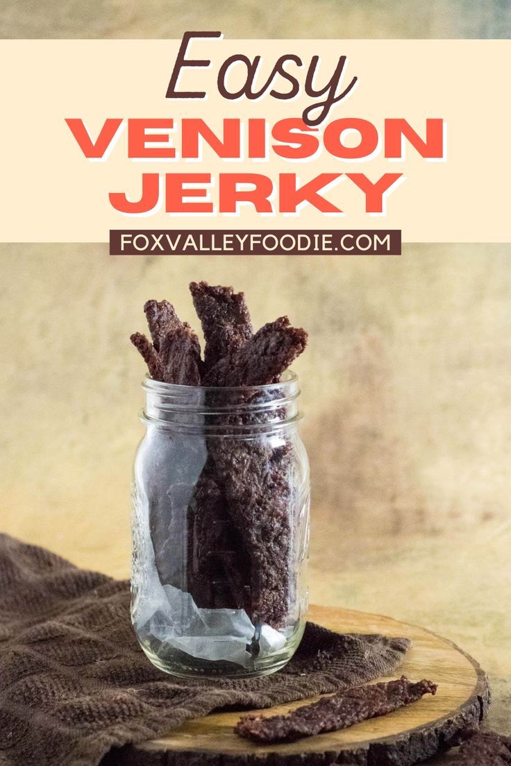 a jar filled with brownie sticks sitting on top of a wooden table next to a napkin