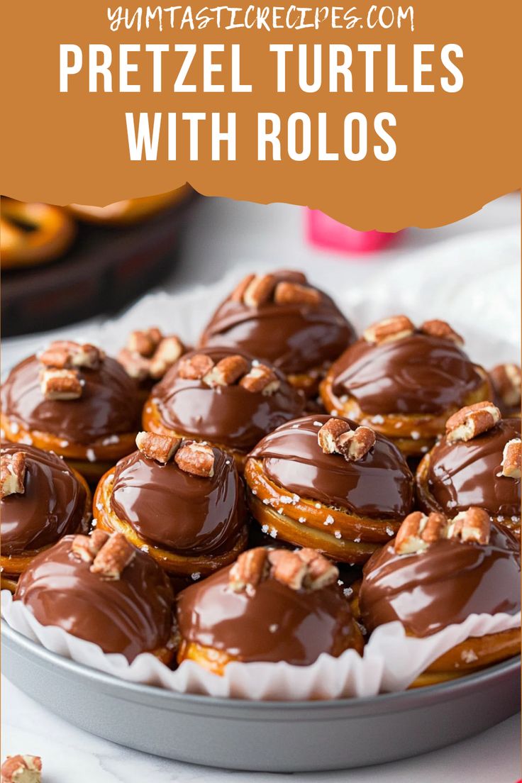 chocolate covered pretzel turtles on a platter with walnuts in the background