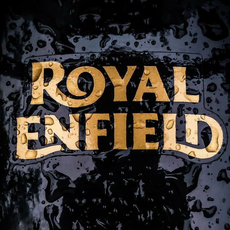 the royal enfield logo is painted on an old black and gold car with drops of water around it