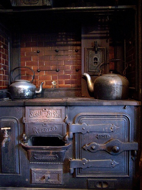 an old fashioned stove with pots and pans on it's burners in a kitchen