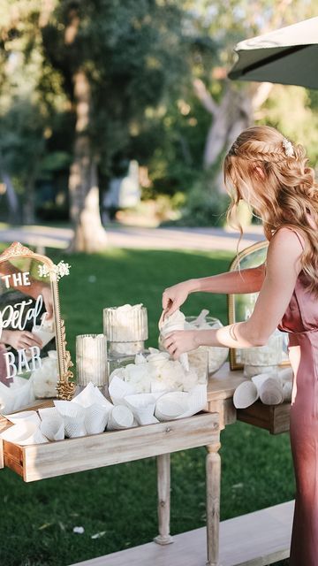 a woman standing in front of a table filled with cakes and marshmallows