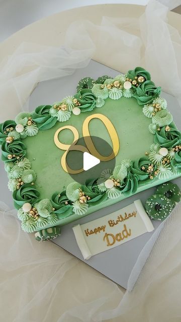 a green birthday cake with the number 80 on it's side and gold decorations