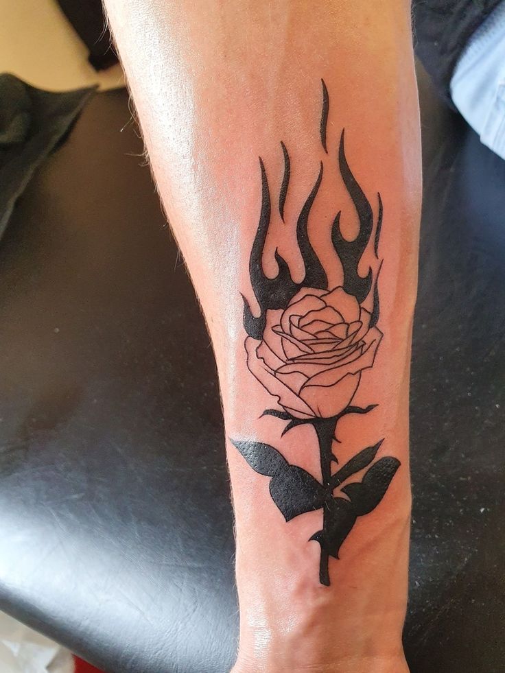 a woman's foot with a rose on it and flames coming out of the flower