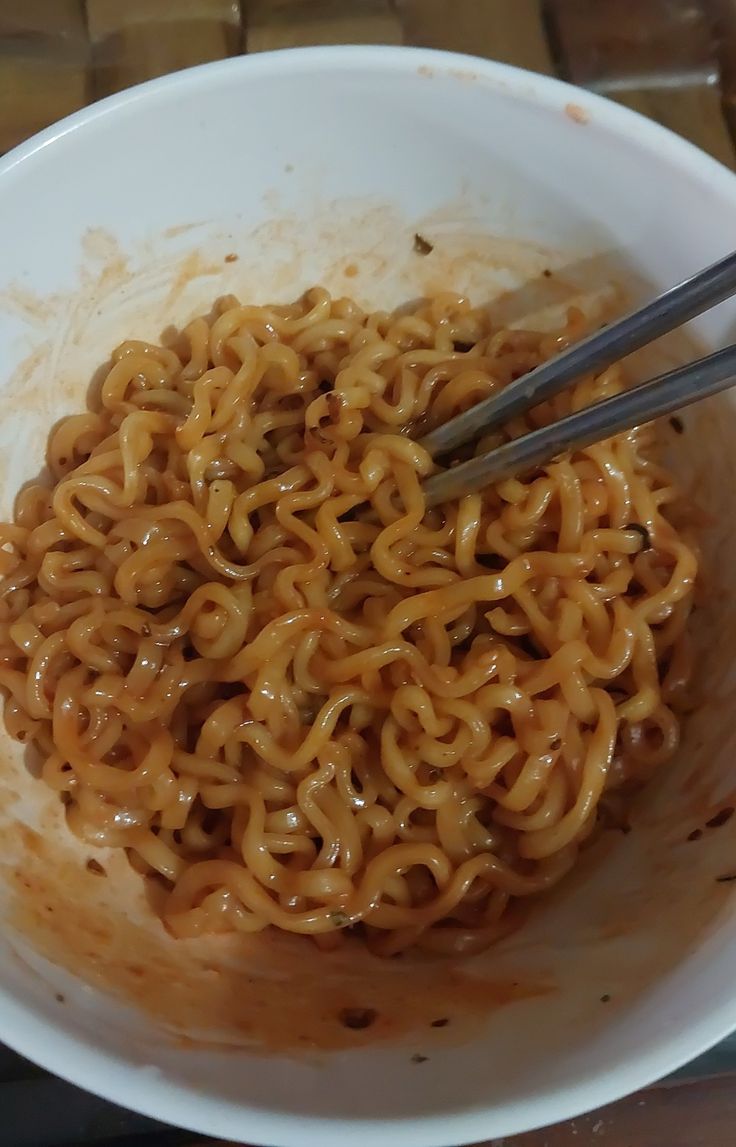 a white bowl filled with noodles and sauce