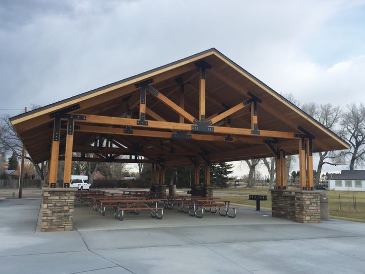 an outdoor pavilion with picnic tables and benches