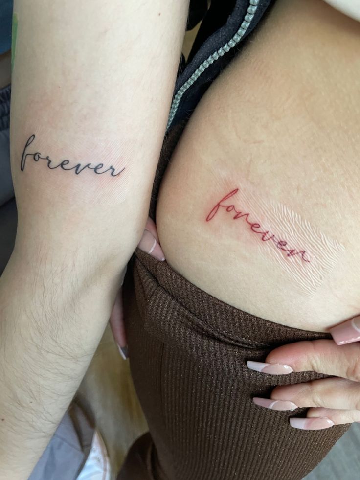 two women with tattoos on their butts, one has the word forever written on it