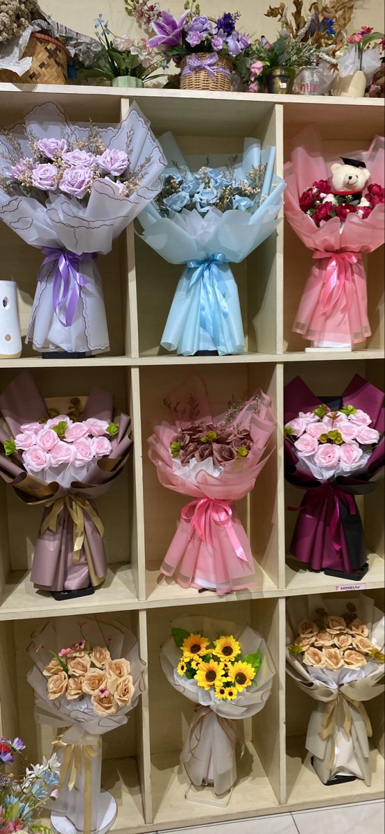 a shelf filled with lots of different types of flowers and bouquets on top of it