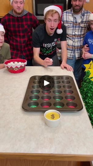 a group of people standing around a table with cupcakes and christmas decorations on it