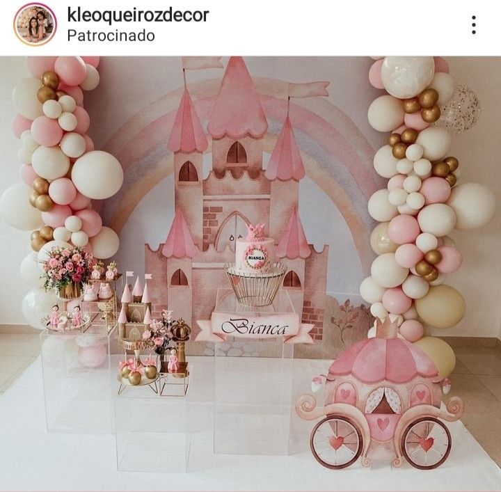 there is a pink princess castle with balloons on the wall and decorations in front of it