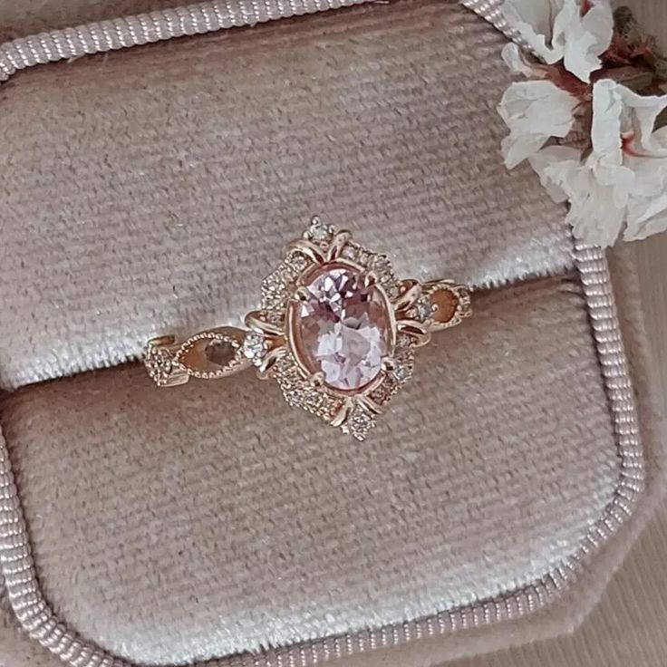 a pink ring sitting on top of a cushion