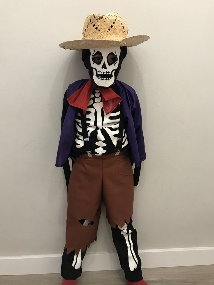 a skeleton wearing a cowboy hat is standing in front of a wall